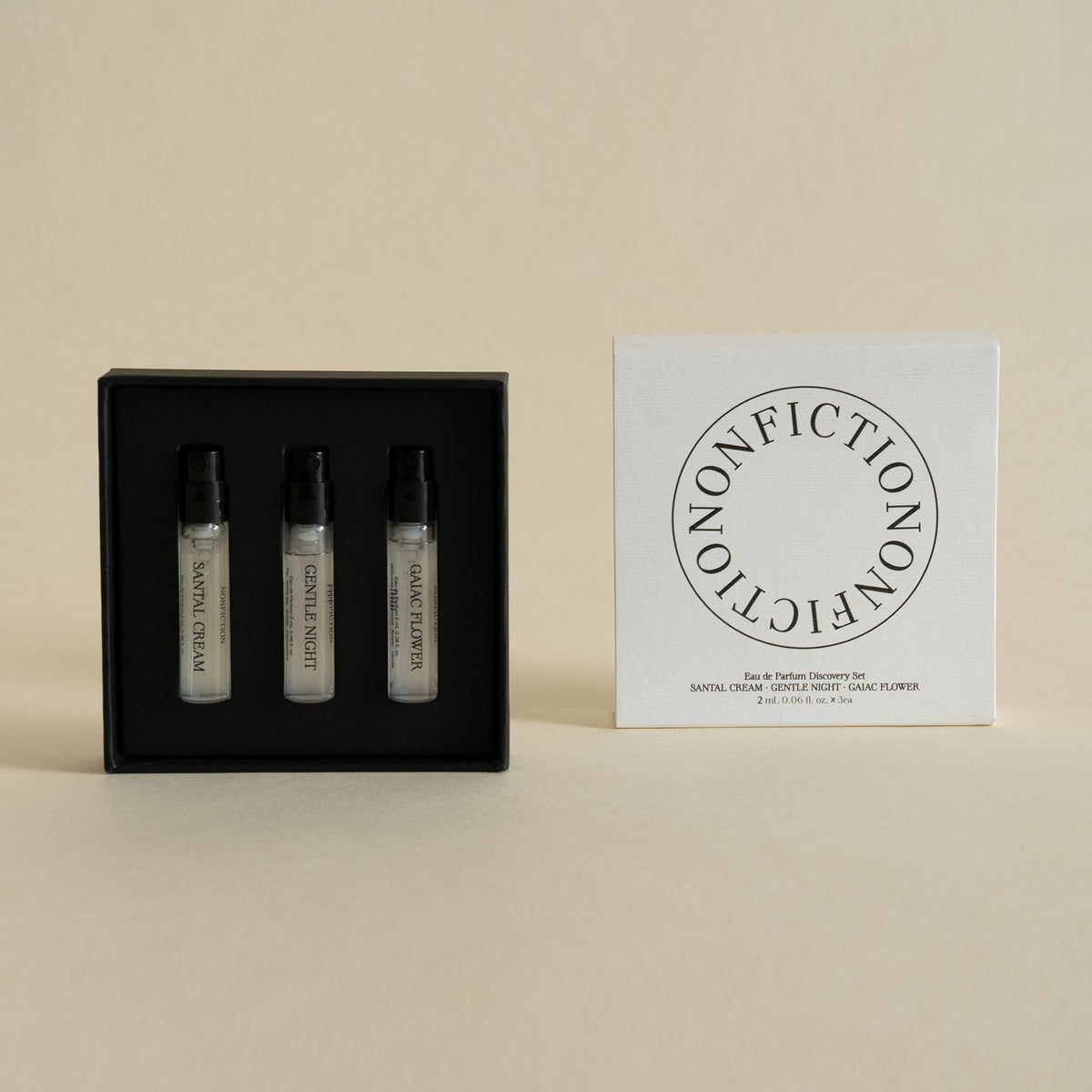 Three small perfume sample vials in a black presentation box beside a white square box printed with the brand name Nonfiction.