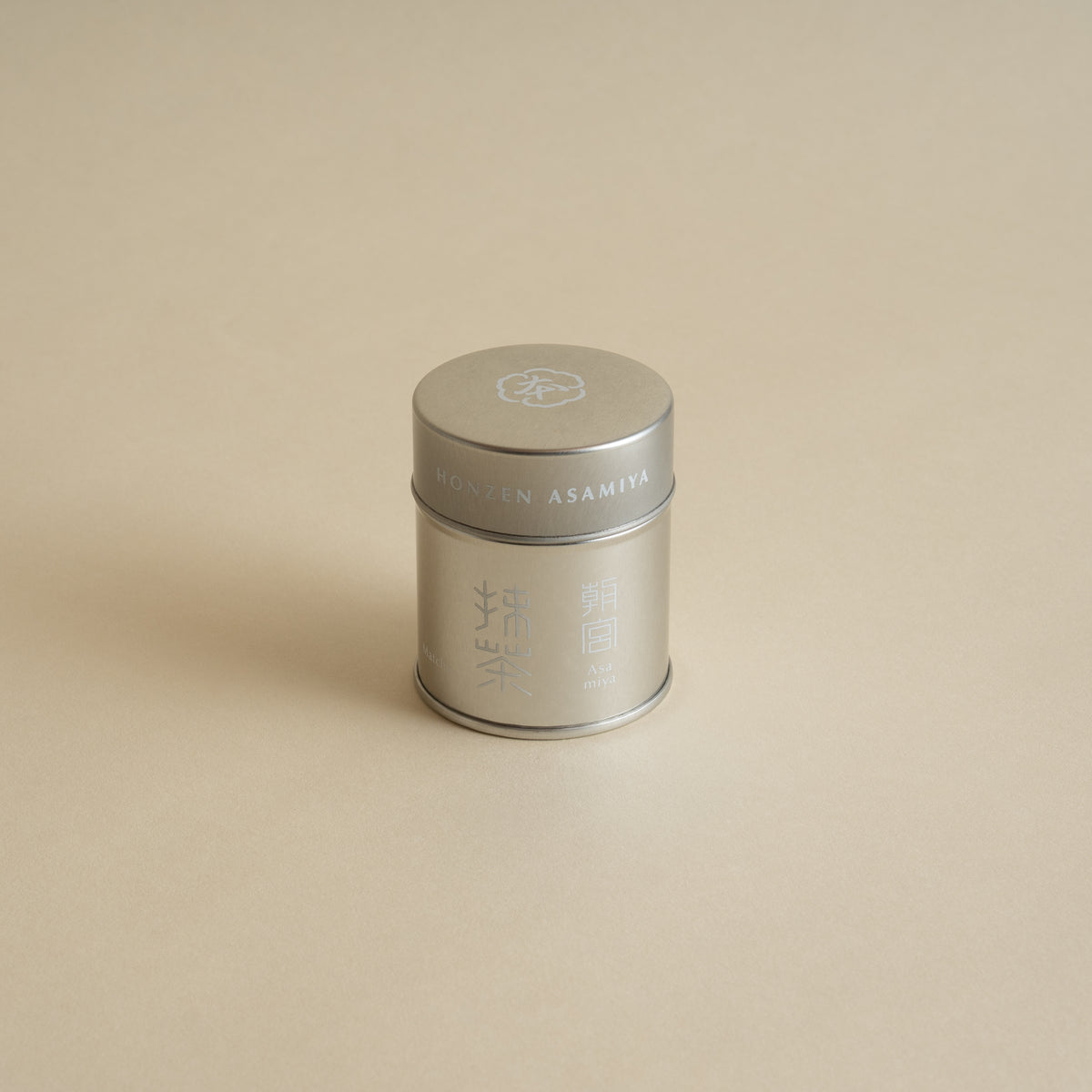 Silver metal tea canister on a beige background
