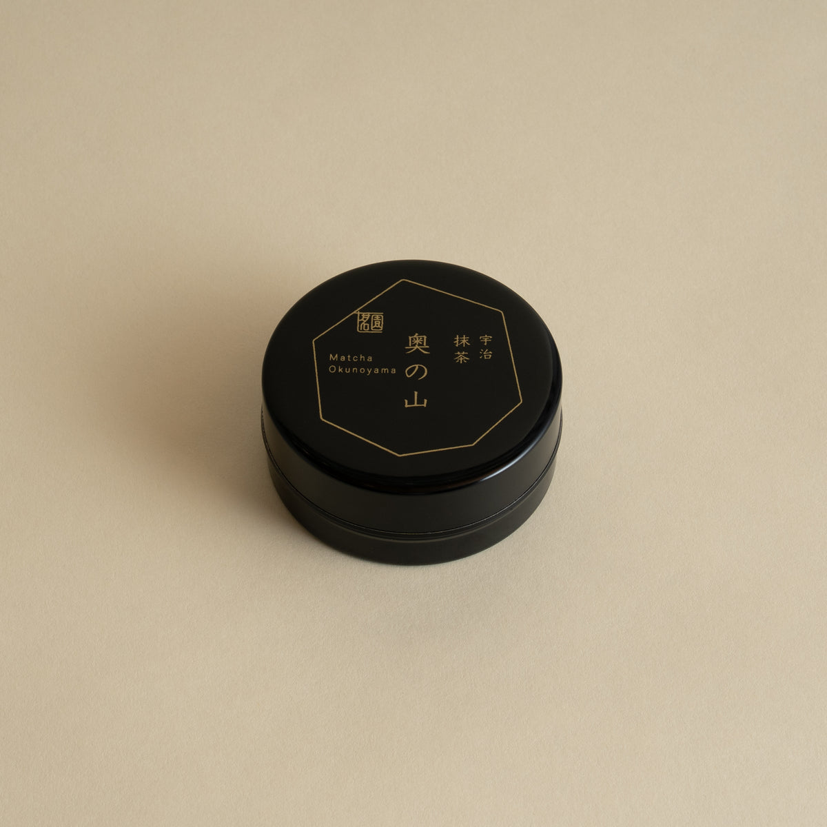 Black container with gold text on a beige background