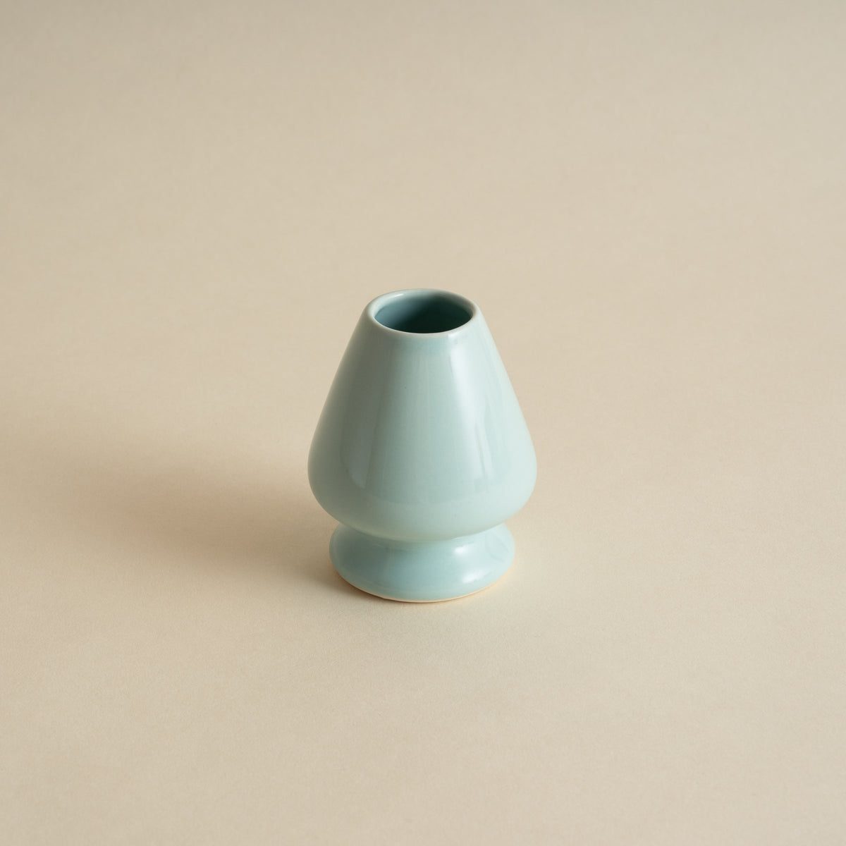 Light blue ceramic vase on a beige background