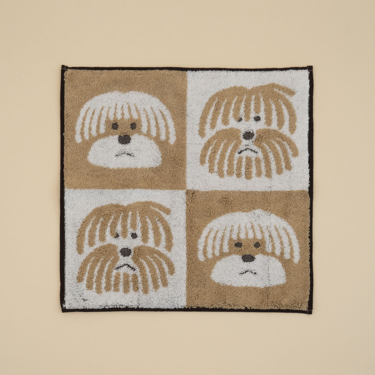Warmgrey Tail terry face towel with fluffy dogs in a brown and white checkerboard pattern