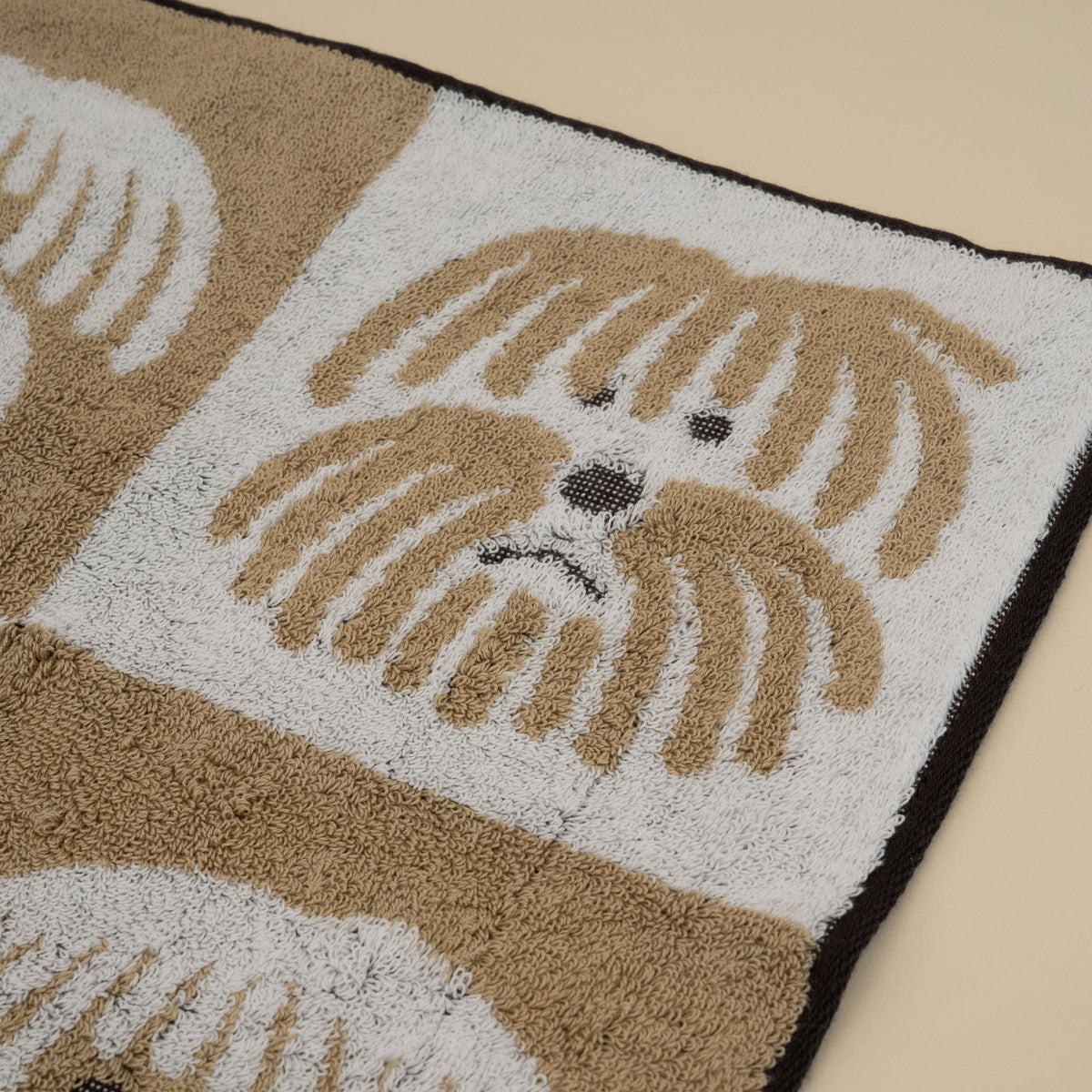 Warmgrey Tail terry face towel with fluffy dogs in a brown and white checkerboard pattern