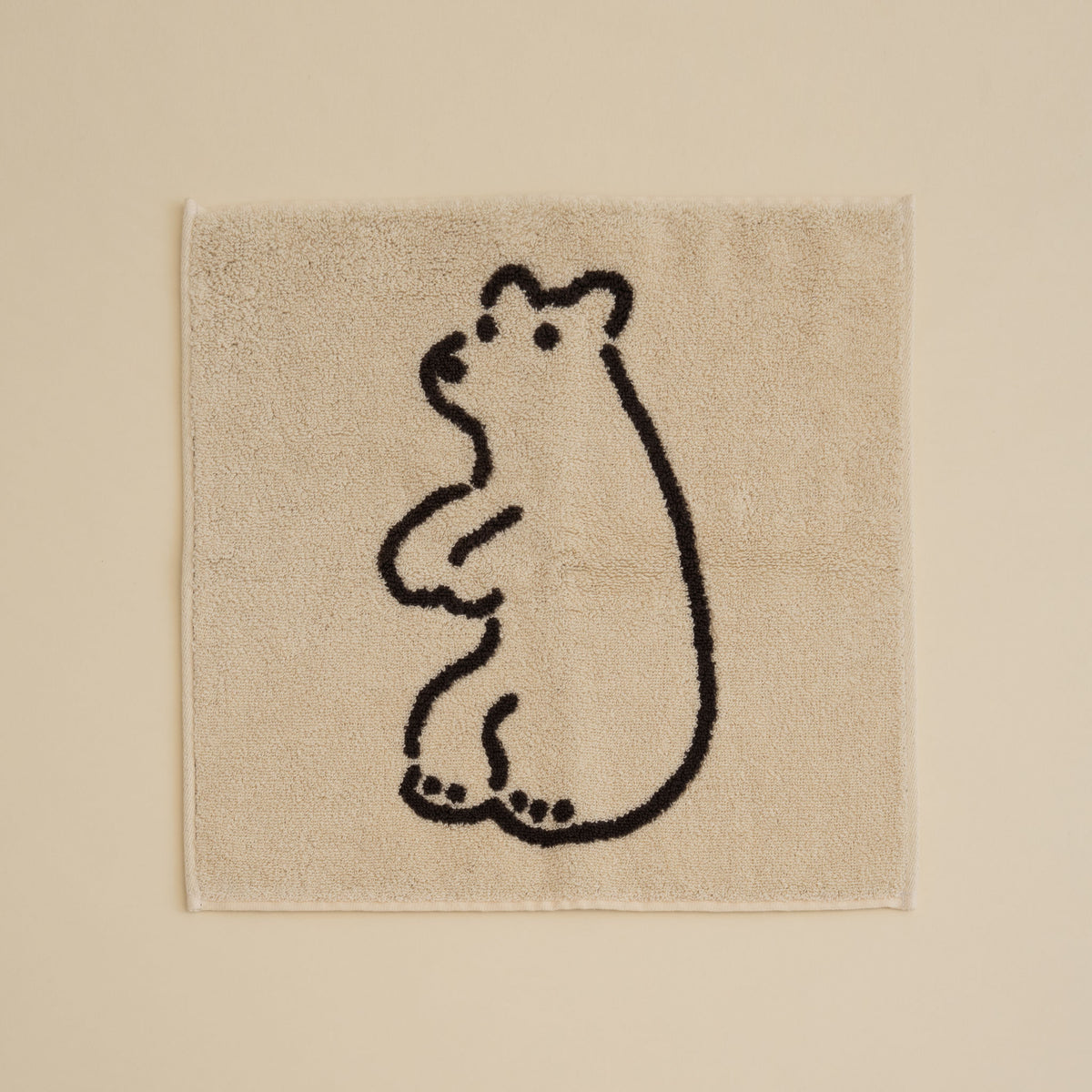 Warmgrey Tail terry face towel with a line-drawn illustration of a standing bear on a cream ground