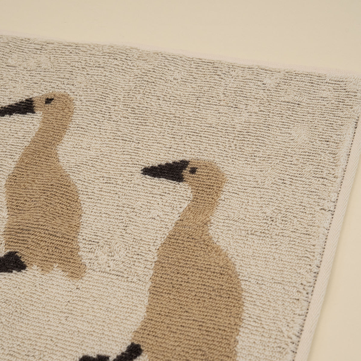 Warmgrey Tail terry face towel with an illustration of three Indian Runner ducks on an ivory ground